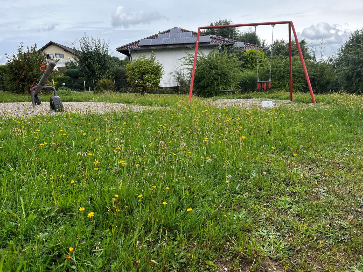 Zu sehen ist ein Spielplatz aus Niederzeuzheim. Das Gras steht hoch und der Platz sieht verlassen und trostlos aus.